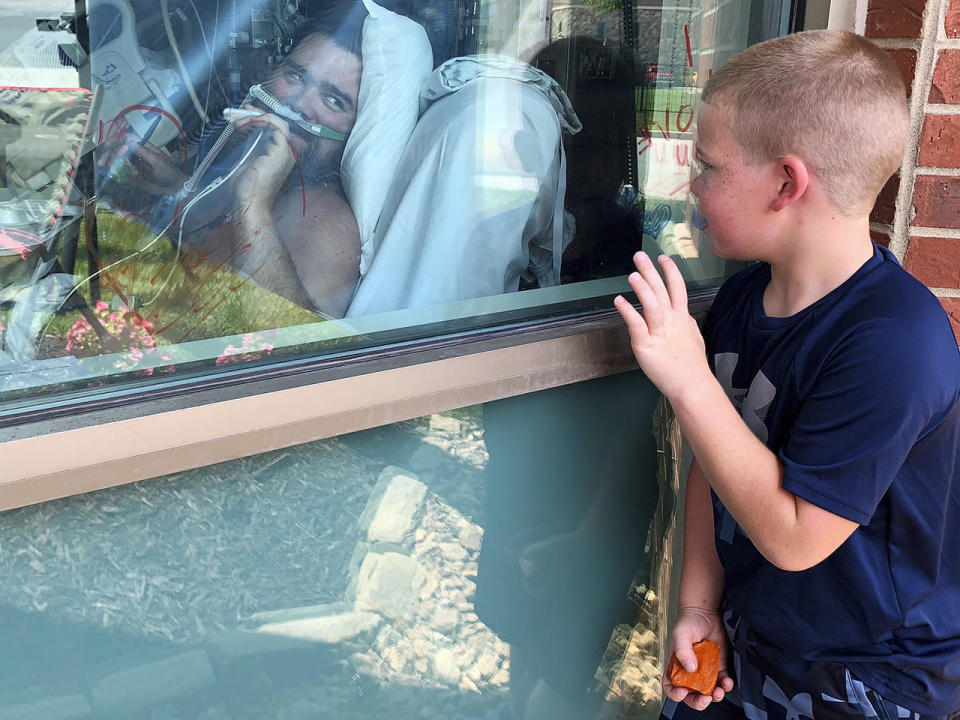 Six-year-old Brody Barker waves to his father, Daryl, from outside his hospital room July 26, 2021, in Osage Beach, Missouri, where Daryl has been hospitalized for nearly three weeks for COVID. Daryl told reporters he had resisted getting vaccinated. / Credit: Sarah Blake Morgan/AP