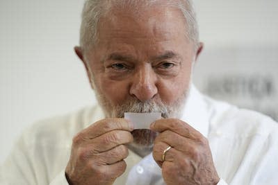 Luiz Inácio Lula da Silva kisses his ticket after voting in the run-off presidential election. (AP Photo/Andre Penner)