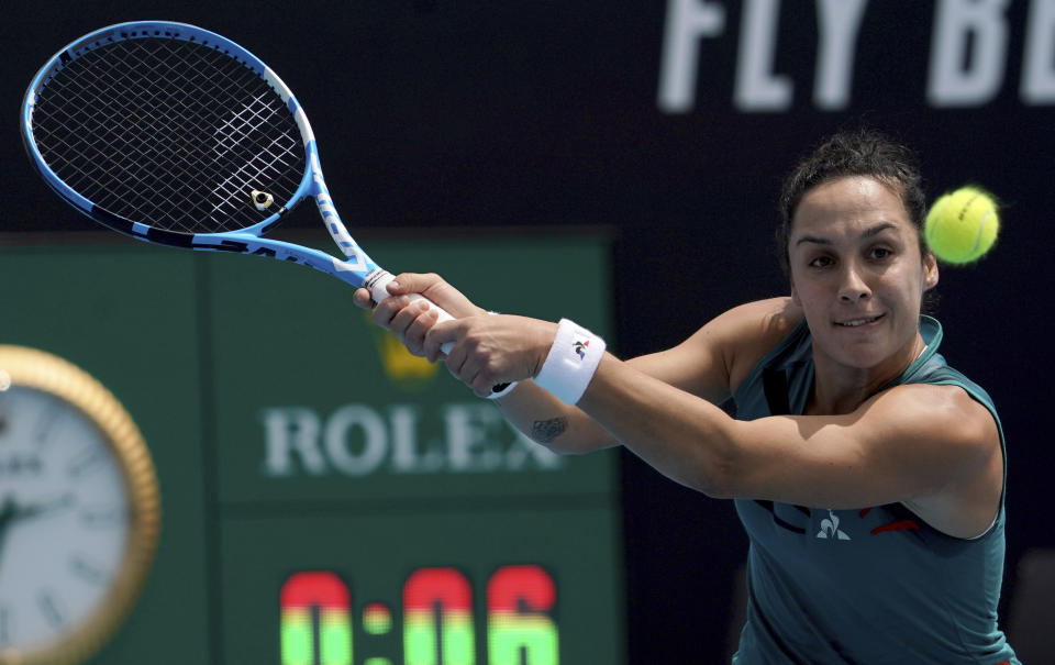 Italy's Martina Trevisan makes a backhand return to Canada's Eugenie Bouchard in their women's singles qualifying match for the Australian Open tennis championship in Melbourne, Australia, Friday, Jan. 17, 2020. (AP Photo/Lee Jin-man)