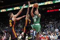 Boston Celtics forward Jayson Tatum (0) shoots as Atlanta Hawks guards Dejounte Murray (5) and Bogdan Bogdanovic (13) defend during overtime in an NBA basketball game Thursday, March 28, 2024, in Atlanta. (AP Photo/John Bazemore)