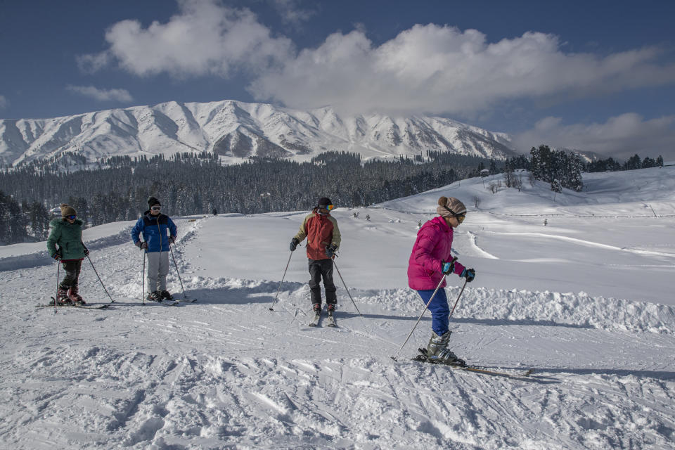 Sukjeet Kaur, 13, a Kashmir school girl skis down a slope as her instructor and friends watch in Gulmarg, northwest of Srinagar, Indian controlled Kashmir, Sunday, Jan. 10, 2021. Kaur, who attended a 15-day skiing course like hundreds of other school students said that this was my chance to be with friends since we have not been able to see each other since long time. And in Gulmarg at least we could be together for 15 days away from COVID related stress and school followed all the COVID related protocol. Snow this winter has brought along with it thousands of locals and tourists to Indian-controlled Kashmir's high plateau, pastoral Gulmarg, which translates as “meadow of flowers." (AP Photo/ Dar Yasin)