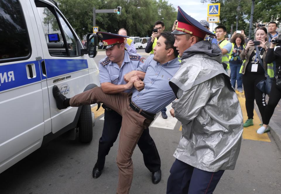 Kazakh police detain a demonstrator in Almaty, Kazakhstan, Wednesday, June 12, 2019, during protests against presidential elections. Protests have continued in the capital, Nur-Sultan, and in Almaty, Kazakhstan's principal city. Police detained 35 people Wednesday in Almaty as they gathered with plans to hold protests, the Interfax news agency reported. (AP Photo/Vladimir Tretyakov)