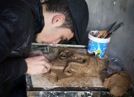 Ninos Thabet, an 18-year-old Christian who studied art at Mosul University, creates miniature replicas of statues destroyed by militants when they overran the 3,000-year-old Assyrian city of Nimrud 2-1/2 years ago, in Erbil, Iraq, January 13, 2017. Picture taken January 13, 2017. REUTERS/Girish Gupta