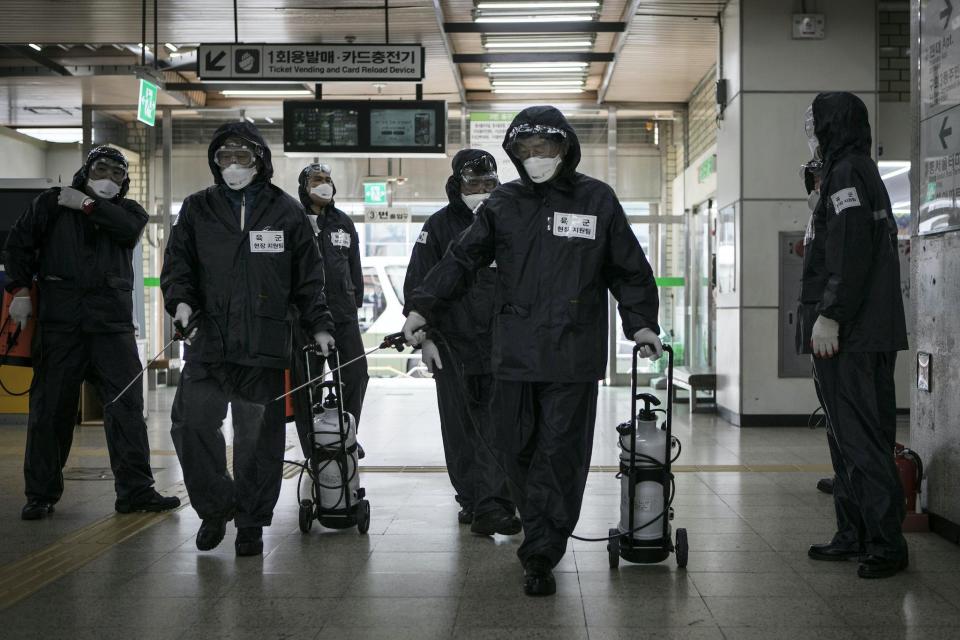 Members of the reserve forces, wearing protective gear, spray antiseptic solution to guard against the coronavirus (COVID-19) at the metro station on March 12, 2020, in Seoul, South Korea: Woohae Cho/Getty Images