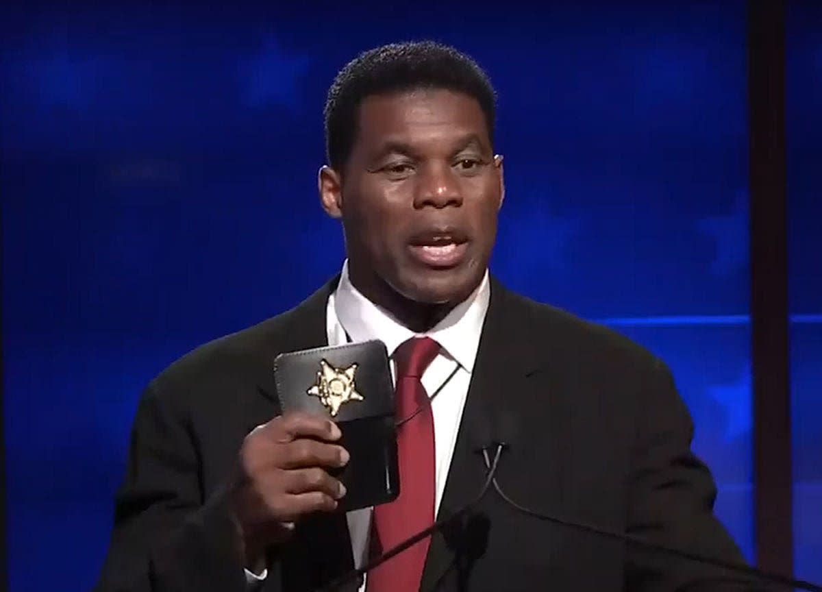 Herschel Walker flashes a ‘prop’ police badge during a Georgia Senate debate.