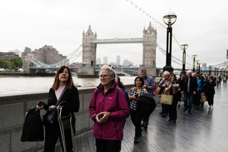 Members of the public queue near to Tower Bridge in London (PA)