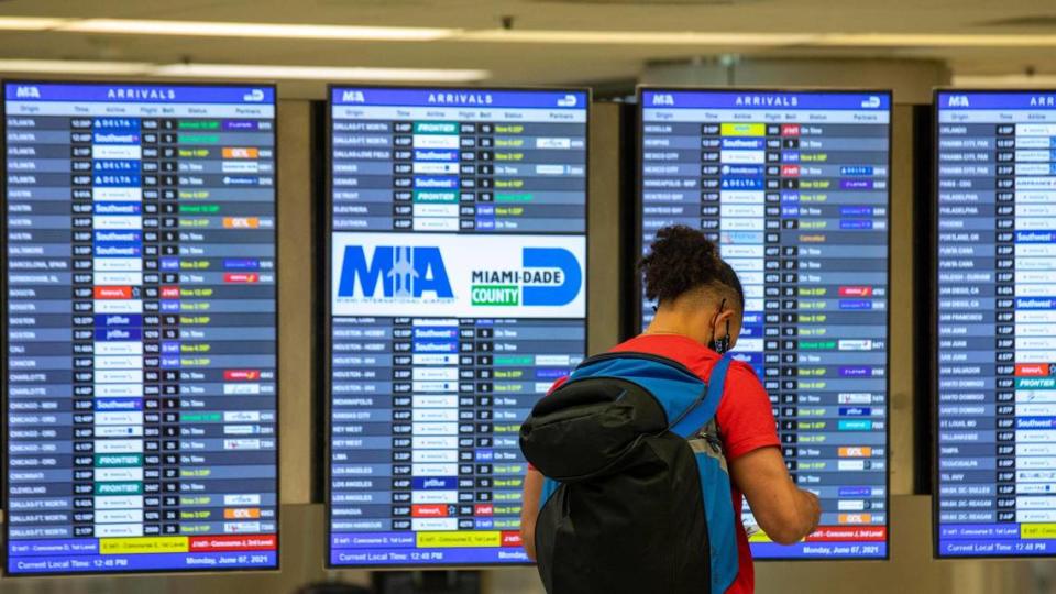 A flight arrivals and departures board at Miami International Airport.