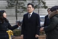 Samsung Electronics Vice Chairman Lee Jae-yong, center, arrives at the Seoul High Court in Seoul, South Korea, Friday, Jan. 17, 2020. Lee appeared in court on Friday for his retrial on the corruption allegations that partially fueled the explosive 2016 scandal that spurred massive street protests and sent South Korea's then-president to prison. (AP Photo/Ahn Young-joon)