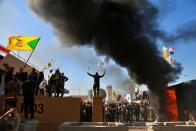 FILE - In this Tuesday, Dec 31, 2019, file photo, protesters burn property in front of the U.S. embassy compound, in Baghdad, Iraq. Iran has had its fingers in Iraq's politics for years, but the U.S. killing of an Iranian general and Iraqi militia commander outside Baghdad has added new impetus to the effort, stoking anti-Americanism that Tehran now hopes it can exploit to help realize the goal of getting U.S. troops out of the country. (AP Photo/Khalid Mohammed, File)