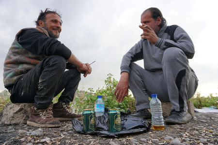 People drink liquor by the river, after it was banned during the Islamic State militants' seizure of the city, in Mosul, Iraq April 20, 2019. REUTERS/Abdullah Rashid