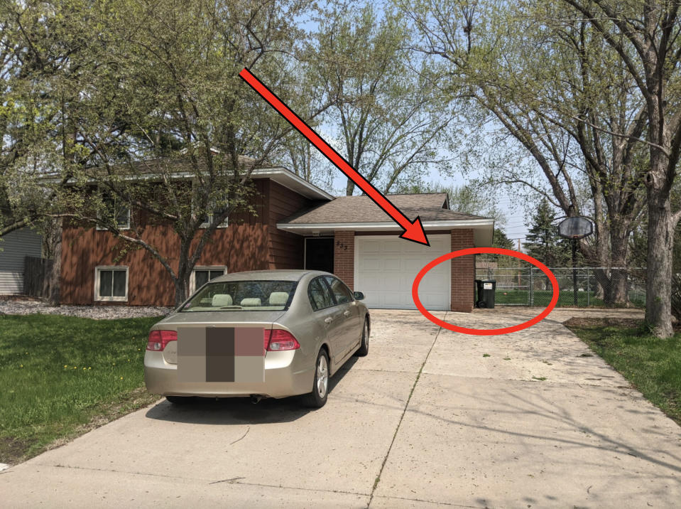 The trash cans are dozens of feet away from the street and are barely visible next to a garage