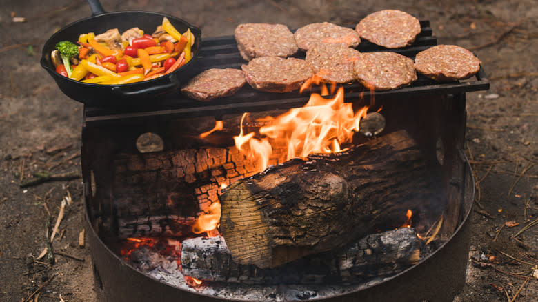 burgers veggies cooking over campfire