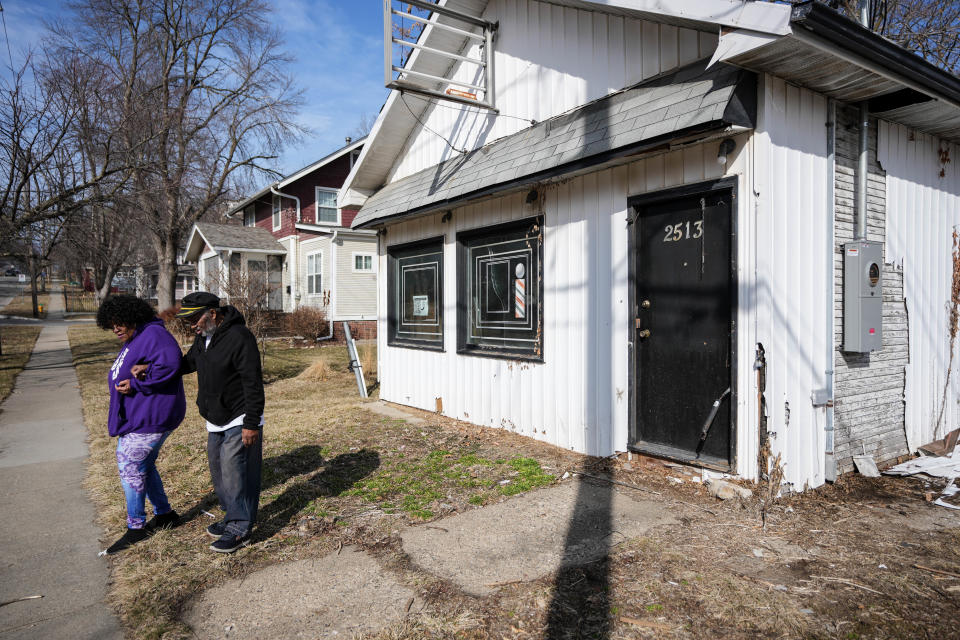 April Thomas helps her husband, Harlan Thomas, to the car after posing for a photo in front of what use to be Harlan's Barber Shop, 2513 Woodland Ave., in Des Moines on Friday, March 3, 2023. Harlan operated his barber shop in this building for nearly 50 years before closing the doors in 2015.