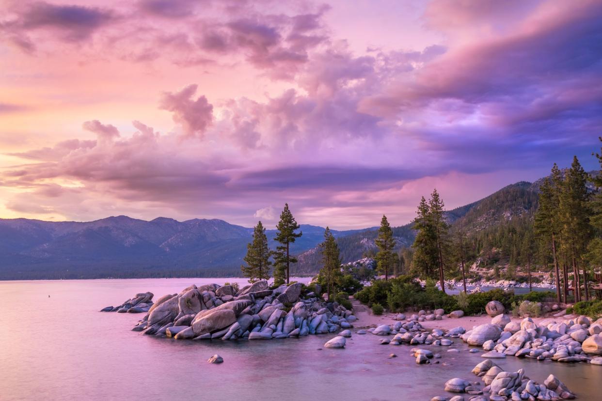 Sunset with cloudy sky over Sand Harbor, Lake Tahoe, Nevada, mountains in the background purple and pink sunset