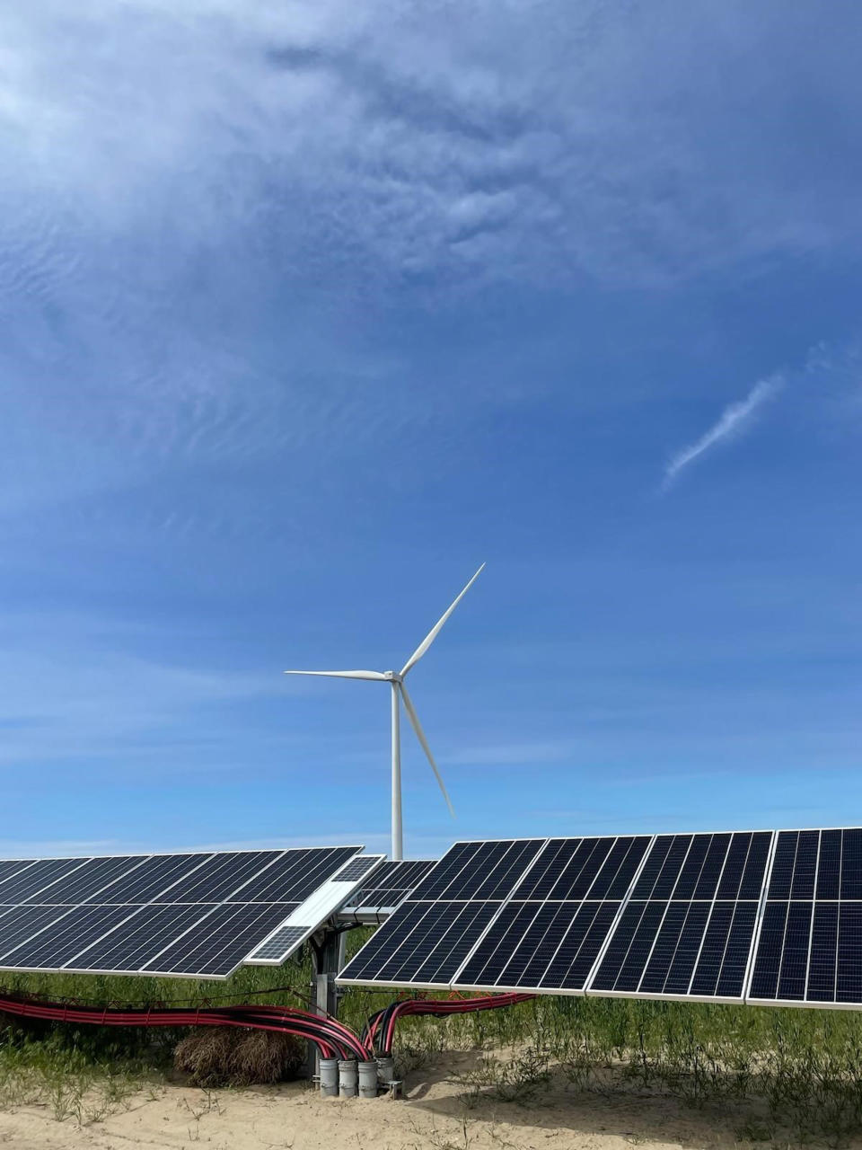 In this image provided by Portland General Electric, windmills and solar panels line a renewable energy facility in Lexington, Ore., on this May 24, 2022. The facility combines solar power, wind power and massive batteries to store the energy generated there. The Wheatridge Renewable Energy Facilities was commissioned Wednesday, Sept. 28, 2022, and is the first utility-scale plant of its kind in North America. Clean energy experts say the project, which can power 100,000 homes, addresses some key challenges facing the industry as the U.S. transitions away from fossil fuels. (Sarah Hamaker/Portland General Electric via AP)