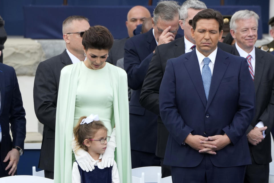 Florida Gov. Ron DeSantis, right, stands for a prayer with his wife Casey and daughter Madison during an inauguration ceremony at the Old Capitol, Tuesday, Jan. 3, 2023, in Tallahassee, Fla. (AP Photo/Lynne Sladky)
