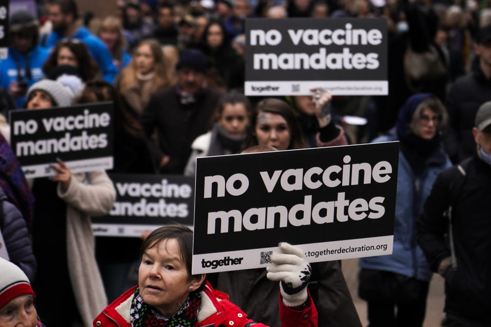 People hold placards as they attend an anti vaccines protest, in London, Saturday, Jan. 22, 2022.(AP Photo/Alberto Pezzali)