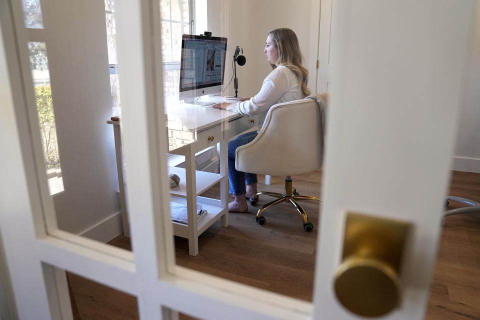 Paige Pritchard, a spending coach who shares financial advice on TikTok, works in her home office, Thursday, Feb. 9, 2023, in Coppell, Texas. At a time when consumers are inundated with so-called social media influencers peddling the latest products online, a slew of TikTok users are leveraging their platforms to tell people what not to buy instead. Pritchard said she chose her career path after blowing her entire $60,000 salary on clothing, beauty and hair products in the first year after she graduated from college. (AP Photo/Tony Gutierrez)