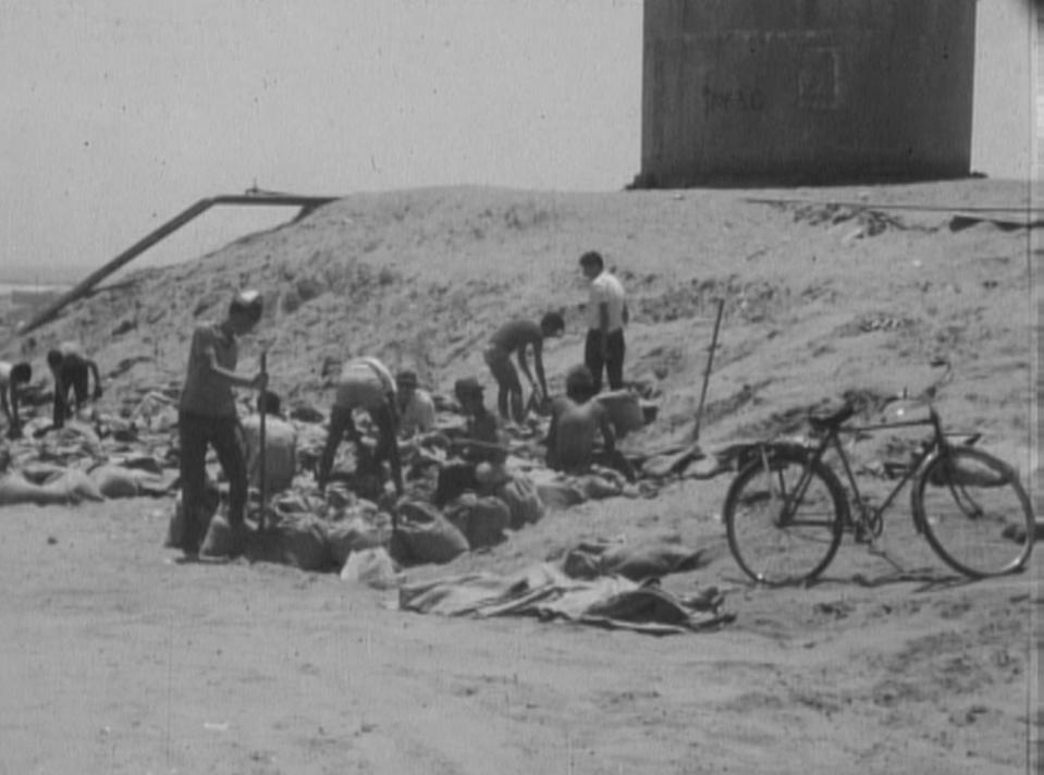 In this image from a British Movietone film screened in 1967, Israelis fill sandbags at Kibbutz Nahal Oz. (British Movietone via AP)