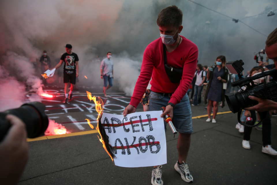 Pavlo Petrychenko burns the poster with the Former Minister of Internal Affairs of Ukraine Arsen Avakov's name on it at the rally in front of the Ministry of Internal Affairs building protesting the inaction of the investigation in identifying the orderers of Kateryna Handziuk's murder in Kyiv, Ukraine, on July 4, 2020. (Stas Yurchenko / Personal archive)