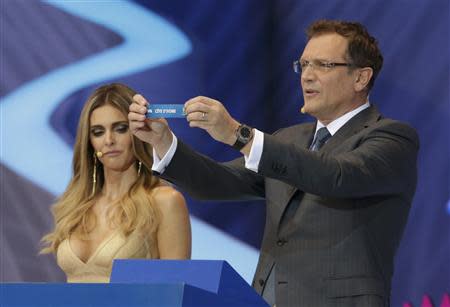 FIFA Secretary General Jerome Valcke holds up the slip showing "Ivory Coast" next to presenter Fernanda Lima during the draw for the 2014 World Cup at the Costa do Sauipe resort in Sao Joao da Mata, Bahia state, December 6, 2013. REUTERS/Ricardo Moraes