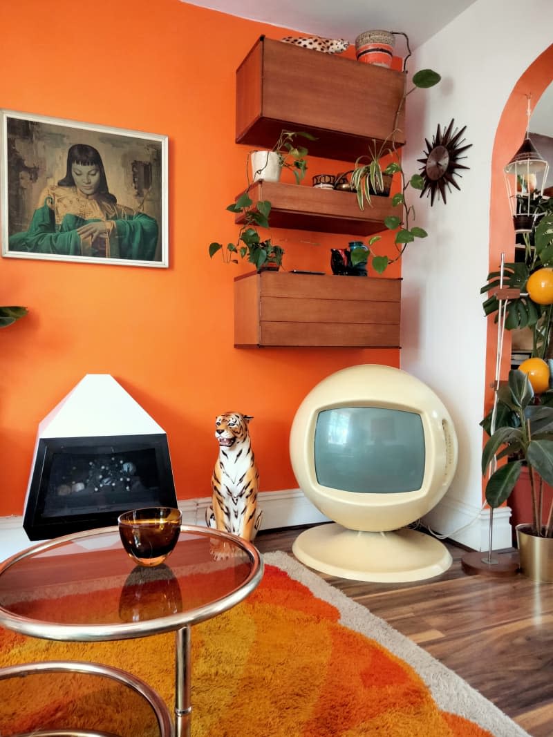 An orange living room with retro 70's items.