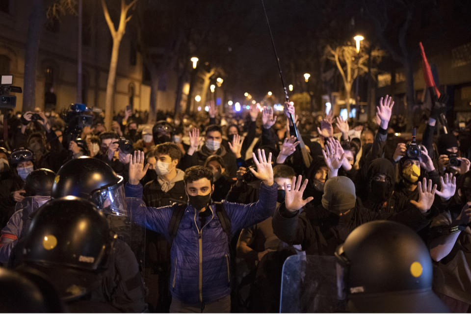 Demonstrators react as police cordon off the street during a march in Barcelona, Spain, Saturday, March 6, 2021. Several hundred protesters are marching in northeastern Spain's Barcelona against the crackdown that has followed the recent violent outcry over the imprisonment of Pablo Hasél, an outspoken anti-establishment artist and activist. (AP Photo/Emilio Morenatti)