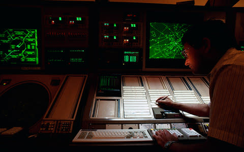 A controller writes on paper flight strips - Credit: Getty