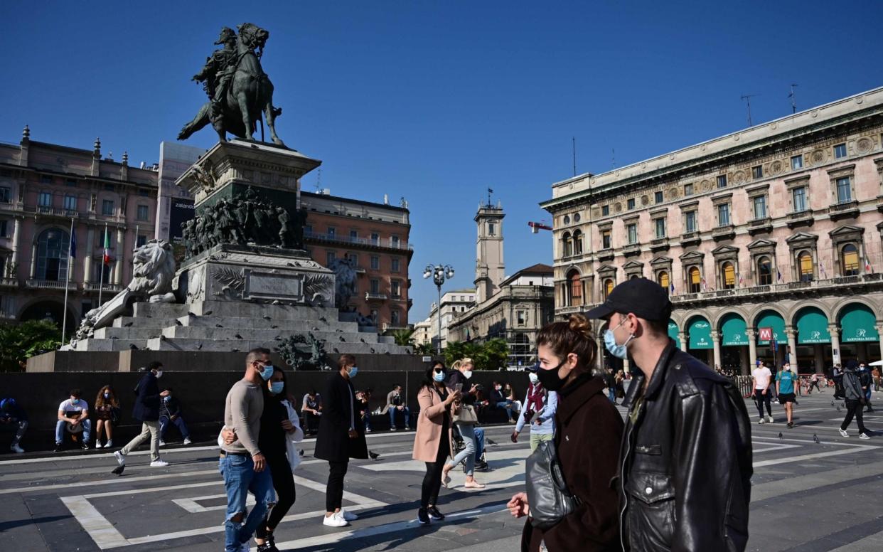 Italy's government has already made it mandatory to wear face masks outdoors. Here people walk through the Piazza del Duomo in Milan. - AFP