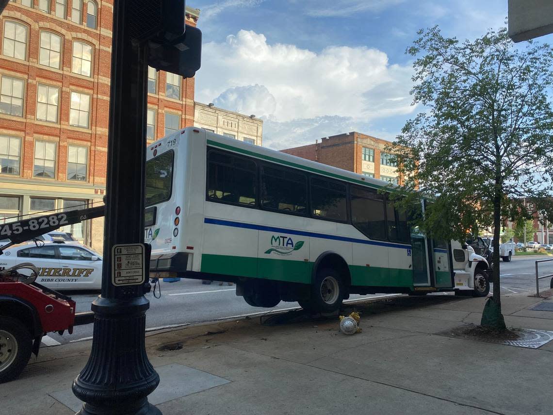 A truck prepares to tow a Macon Transit Authority bus that was involved in a collision Thursday evening in downtown Macon.