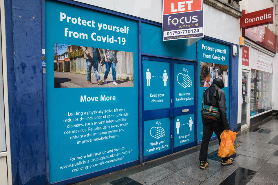 A member of the public passes COVID-19 public information displays on 4 October 2020 in Slough, United Kingdom. Slough Borough Council confirmed on 2nd October that its coronavirus infection rate is the highest in the south of England and Slough MP Tan Dhesi asked Health Secretary Matt Hancock in Parliament whether the local test centre in Montem Lane could be reverted to permit walk-in and drive-in visits without an appointment. (photo by Mark Kerrison/In Pictures via Getty Images)