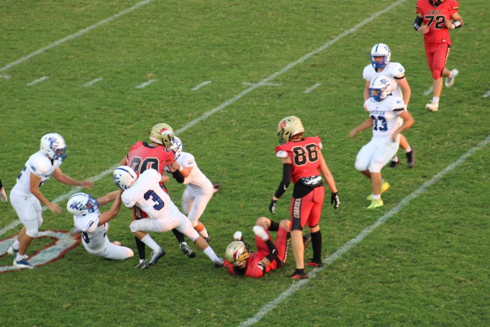 Members of the Spencer County High School defense tackle Bullitt East's Nolan Davenport during a game Friday, Aug. 26, 2022, in Mt. Washington, Ky. The Bears defeated the Chargers 19-16.