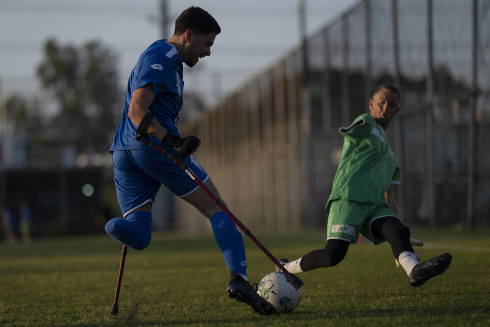 Israel Amputee Football Team soccer player, left, Omer Gliksta kicks the ball as his teammate, the goalkeeper, Or Hershkovits, tries to block it during a practice session in Ramat Gan, Thursday, April 11, 2024. Glikstal, 20, of Haifa, was a dedicated athlete who played football regularly. But during a battle in Gaza in November against Hamas militants, he was struck in the left foot by a rocket-propelled grenade. Being on the amputee team has renewed him, mentally and physically. (AP Photo/Leo Correa)