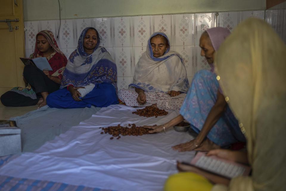 40-year-old Naseema Ben Shamdar, second left, a survivor of a bridge collapse, mourns at her house in Morbi town of western state Gujarat, India, Tuesday, Nov. 1, 2022. Naseema and seven members of her family were walking on the congested suspension bridge when its cables gave away, sending them all plunging head-first into the wide Machchu river. She lost her daughter Muskan, 21, two nephews, two nieces and two sister-in-laws that night. (AP Photo/Rafiq Maqbool)