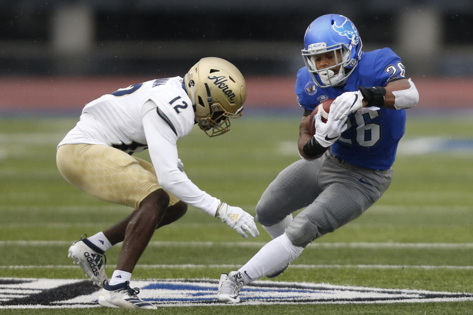 Buffalo running back Jaret Patterson (26)  is tackled by Akron's Charles Amankwaa (12) during the first half of an NCAA college football game at UB stadium in Amherst, N.Y., Saturday Dec. 12, 2020. (AP Photo/Jeffrey T. Barnes)