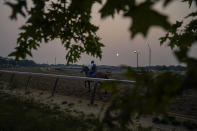 Haze from northern wildfires obscures the rising sun as horses train ahead of the Belmont Stakes horse race, Wednesday, June 7, 2023, at Belmont Park in Elmont, N.Y. (AP Photo/John Minchillo)