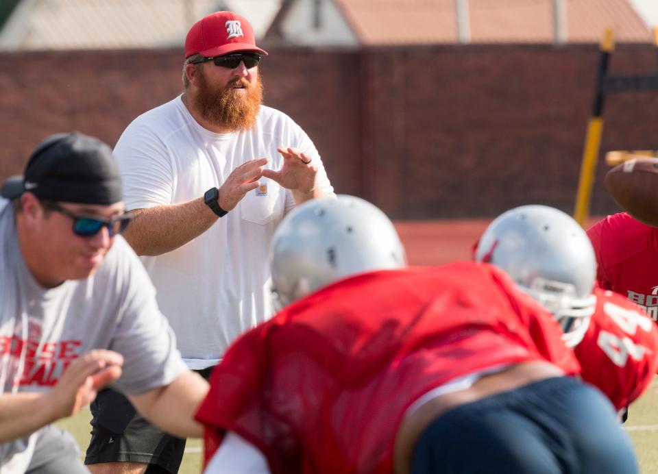 Bosse head coach Stephan Mullen, center, waits for the snap during summer workouts at Enlow Field Tuesday evening, July 13, 2021.