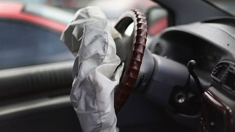 A photo of an airbag seen after deployment, inside a car interior.