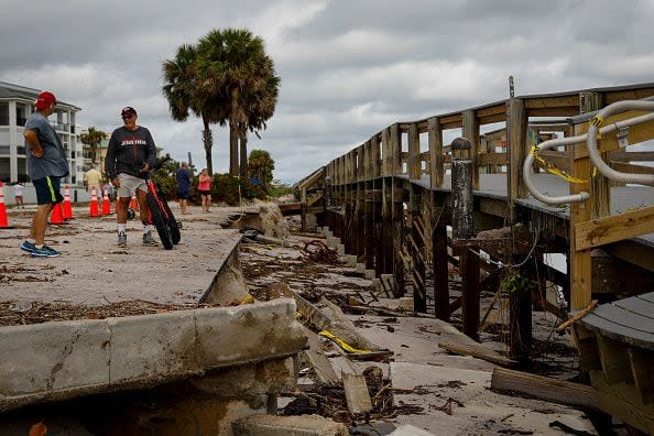 People inspect the partially damaged Vero Beach Boardwalk after Hurricane Nicole's landfall, Vero Beach, Florida, on November 10, 2022. - Tropical Storm Nicole slowed after making landfall in the US state of Florida, meteorologists said Thursday. (Photo by Eva Marie UZCATEGUI / AFP) (Photo by EVA MARIE UZCATEGUI/AFP via Getty Images)