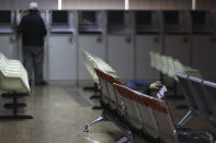 A Chinese woman browses on her mobile phone at a brokerage in Beijing, China, Tuesday, Dec. 25, 2018. Japanese stocks plunged Tuesday and other Asian markets declined following heavy Wall Street losses triggered by President Donald Trump's attack on the U.S. central bank. (AP Photo/Ng Han Guan)