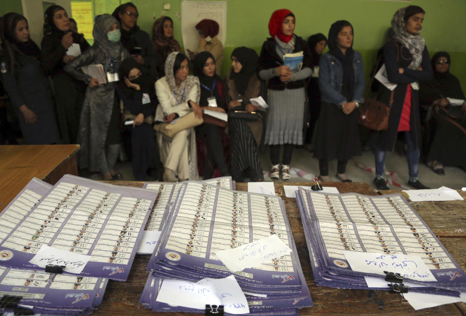 Election observers watch the counting of ballots during parliamentary elections, at a polling station in Kabul, Afghanistan, Sunday, Oct. 21, 2018. The elections entered a second day after delays caused by violence and technical issues, as a roadside bomb killed nearly a dozen civilians on Sunday, including several children. (AP Photo/Rahmat Gul)