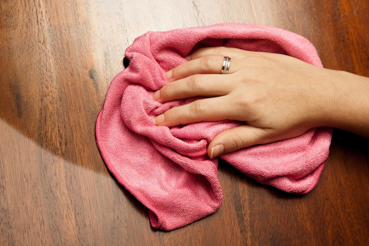 dusting of wood table with soft cloth