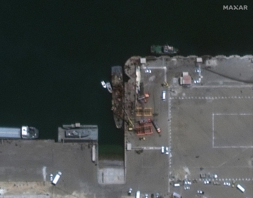 In this satellite photo provided by Maxar Technologies, the Iranian naval support vessel Konarak, center, is tied up at the port in Konarak, Iran, on Monday, May 11, 2020. A missile fired during an Iranian military training exercise mistakenly struck the naval vessel instead of its intended target in waters near the strategic Strait of Hormuz, killing and wounding a number of sailors, Iranian authorities said Monday. (Maxar Technologies via AP)