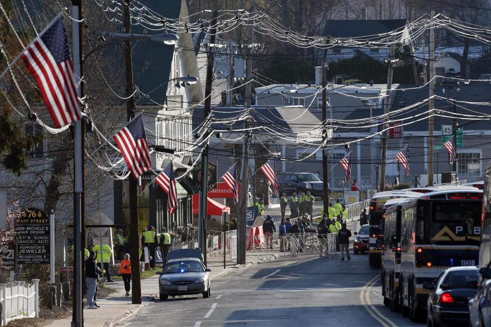 Buses carrying runners arrive at sunrise in Hopkinton, Mass., for the start of the 118th Boston Marathon Monday, April 21, 2014. (AP Photo/Michael Dwyer)