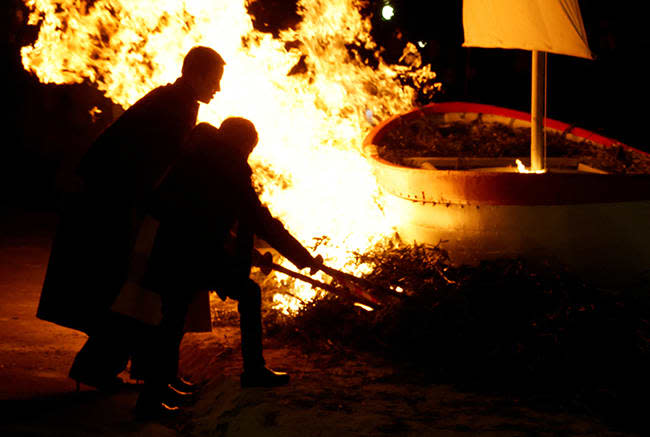 Princess Charlene lighting a fire with Prince Jacques and Princess Gabriella