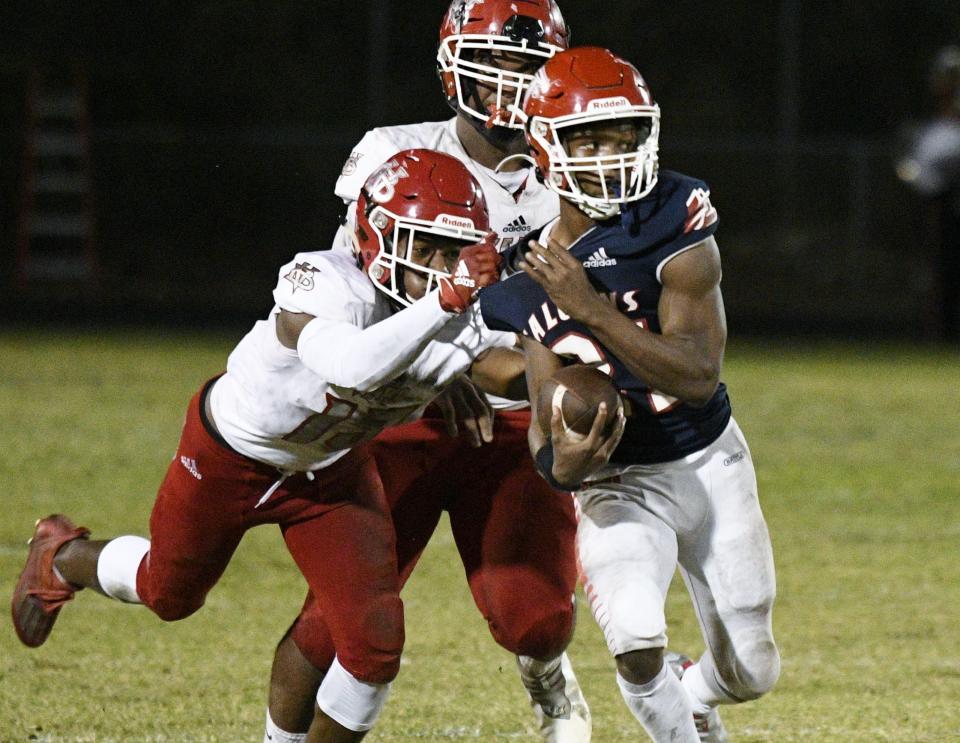 Forest Hill's Melvin Hubbard tries to fight off tackles during a second-quarter run against Vero Beach in the 2021 FHSAA state tournament.