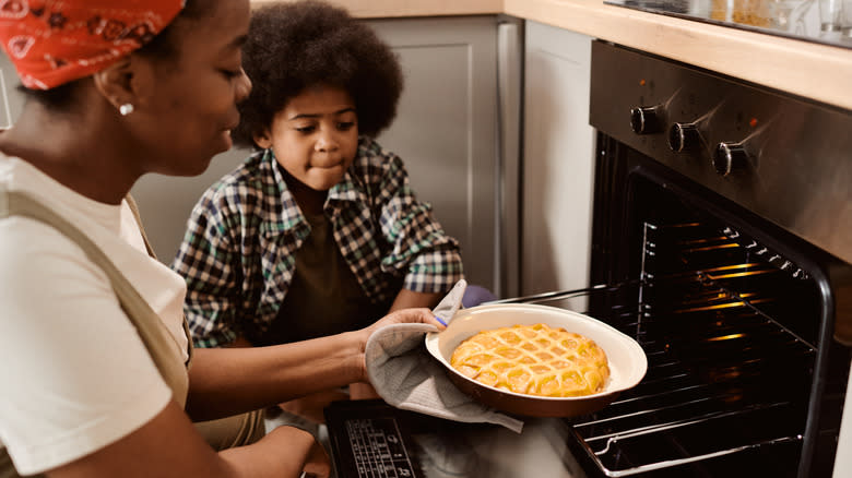 A woman and a little boy bake an apple pie