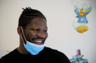 Hassan N'Dam, excampeón mundial, sonríe al ser fotografiado en el hospital de Villeneuve-Saint-Georges, en las afueras de París, donde ofrece clases de boxeo al personal que atiende a su suegro, quien lucha contra el coronavirus. Pensó en regalarles champagne o chocolate, pero lo descartó. "Quería darles algo que fuese memorable", cuenta N'Dam. (AP Photo/Christophe Ena)