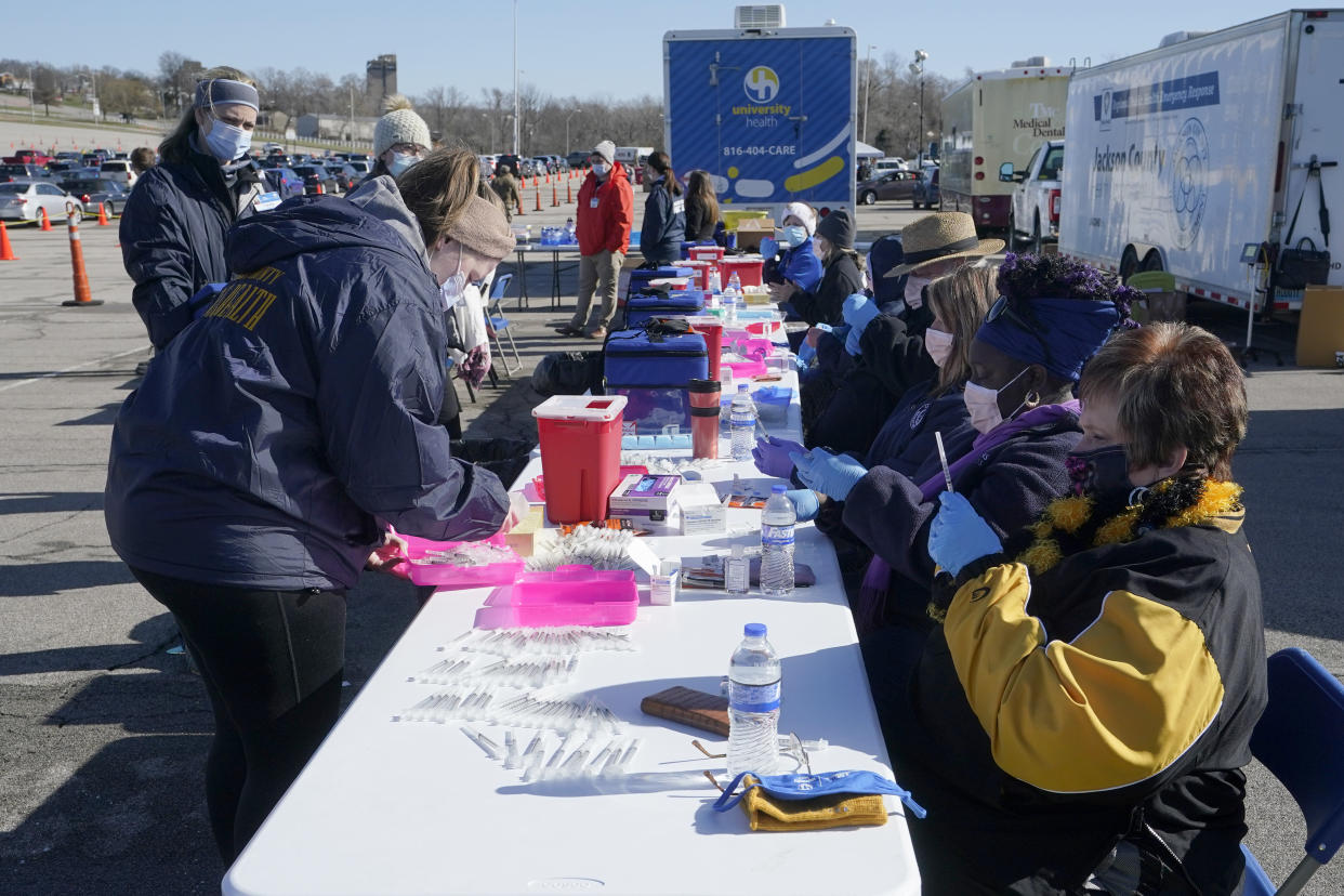 Nurses fill syringes with a COVID-19 vaccine at a mass vaccination site in Kansas City, Mo. in March. (Orlin Wagner/AP)