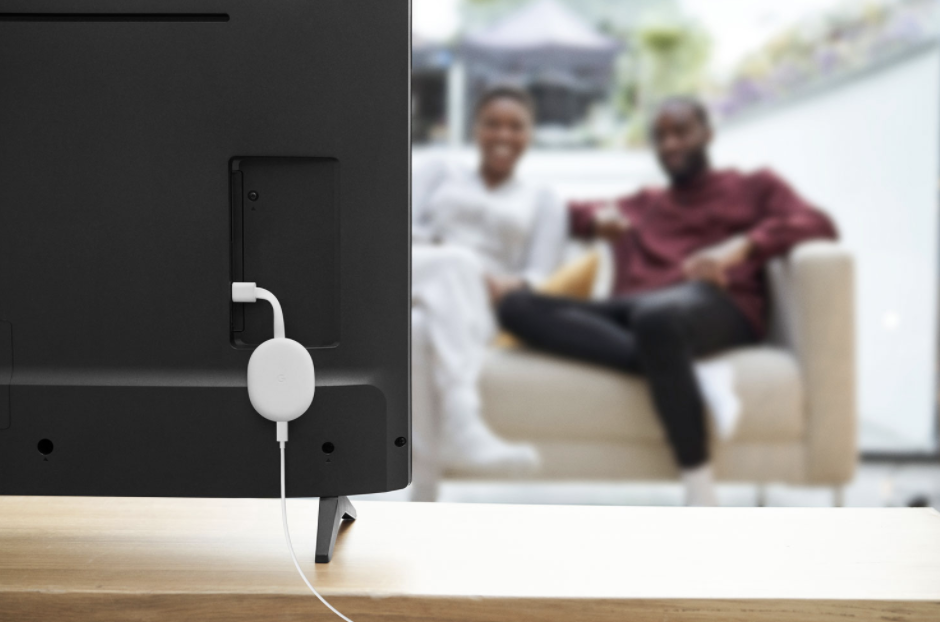 couple watching tv and Google Chromecast with Google TV plugged into tv (Photo via Best Buy Canada)